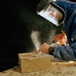 A man chiselling a piece of stone A man chiselling a piece of stone